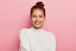 immagine di copertina articolo di approfondimento sul Pap-Test e la sua importanza nella prevenzione, ragazza sorridente su sfondo rosa